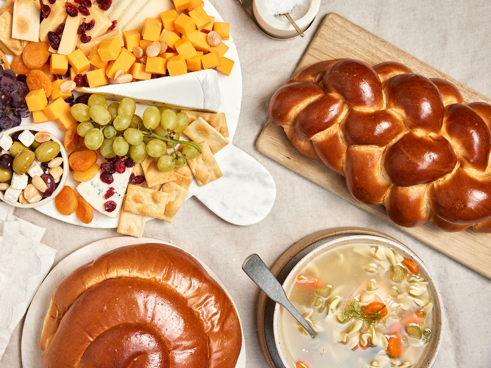 A Yom Kippur break fast of challah, soup, fruits, and cheese.
